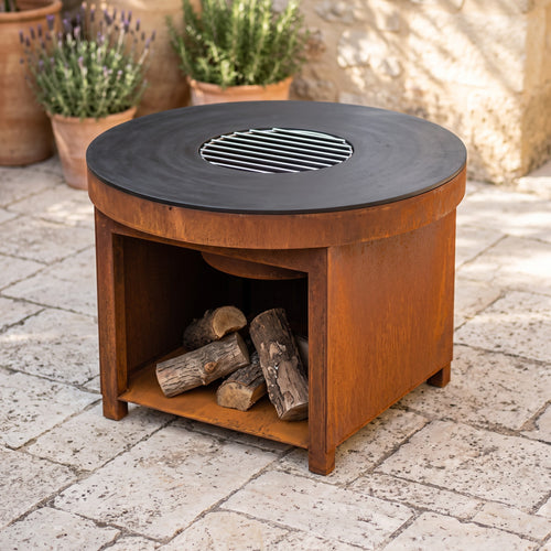 Mesa brasero de acero corten de 100 cm con plancha y leñero integrado