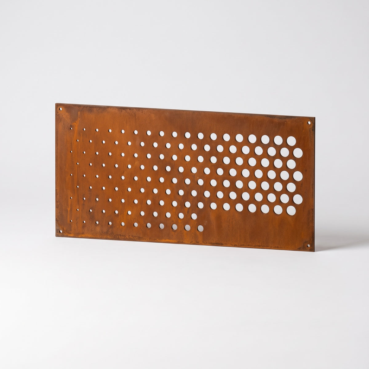 Detalle del corte láser en un panel de corten con taladros de fijación